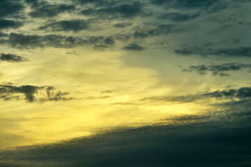 sunset sky with yellow lights and dark mottled clouds