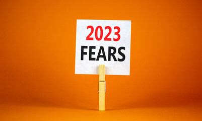 2023 Fears symbol. White paper with words 2023 Fears, clip on wooden clothespin. Beautiful orange...