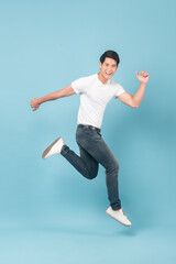 Nice asian guy in white t-shirt and jeans jumping isolated on blue background