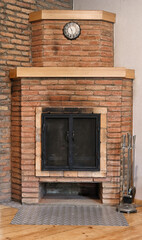 Old brick fireplace with black doors