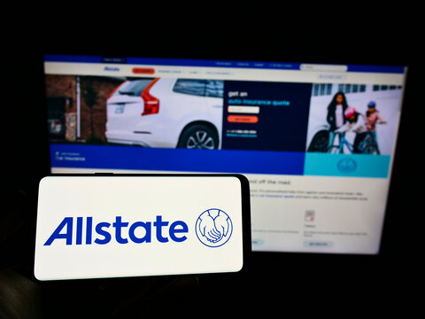 Stuttgart, Germany - 12-12-2021: Person holding smartphone with logo of US insurance company The Allstate Corporation on screen in front of website. Focus on phone display.
