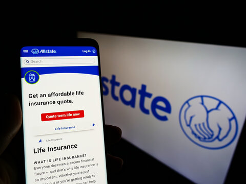 Stuttgart, Germany - 12-12-2021: Person holding smartphone with website of US insurance company The Allstate Corporation on screen with logo. Focus on center of phone display.