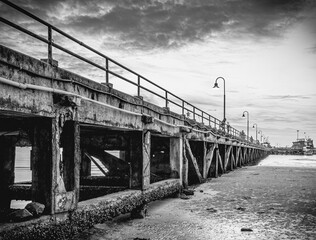 Old bridge over the sea. An old pier in black and white.