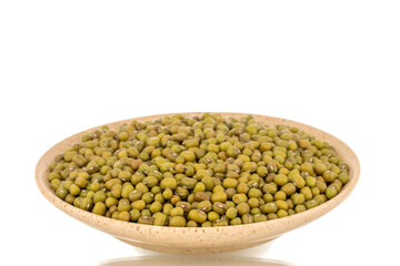 Plenty of organic uncooked mung beans in a  ceramic saucer, close-up, isolated on a white background.	