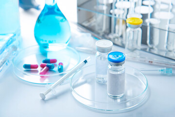 Vaccination concept with syringe, vial vials and Different laboratory glassware with color liquid and with reflection 