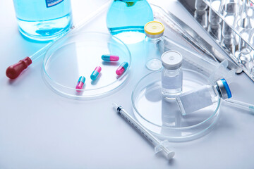 Vaccination concept with syringe, vial vials and Different laboratory glassware with color liquid and with reflection 