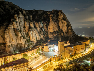 Paisaje nocturno de la montaña de Montserrat con el monasterio iluminado en Cataluña (España).