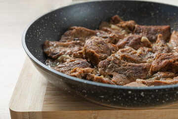 Juicy pieces of beef steak in a frying pan with spices and salt. Delicious food concept. Recipe for cooking juicy meat.