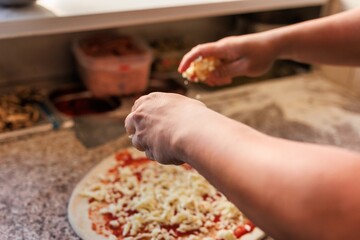 Pizzeria chef unrecognizable hands preparing a fresh pizza. professional kitchen making bakery