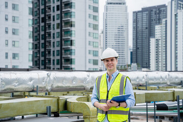An engineer's portrait is examining the cooling tower air conditioner of a huge industrial building to control airflow.