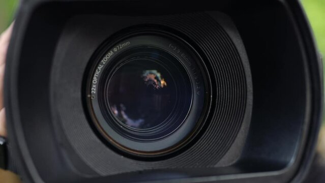 Focusing and Zooming Camcorder Lens. Closeup Professional Video Camera In Hands Of Videographer