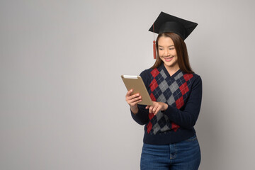 Young smiling woman holding graduation hat, education and university concept.