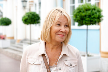 Fototapeta premium Close-up of an elderly cheerful woman. A positive mood and a smile on your face. A walk in your free time.