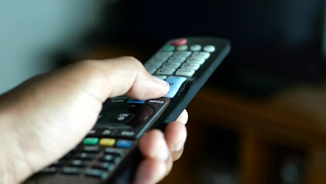 close up of man hand holding tv remote.