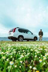 man standing near car at seaside. road trip concept