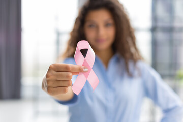 October breast cancer awareness month, woman with hand holding pink ribbon for supporting people...