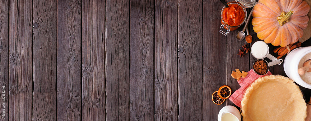 Aufkleber Autumn baking side border with pumpkin pie ingredients. Overhead view on a dark rustic wood banner background with copy space.