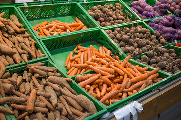 fresh carrots on the counter, washed vegetables in plastic boxes in the supermarket