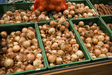 onions on the counter , vegetables in boxes in the supermarket