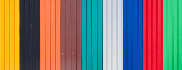 Background of multicolored corrugated metal sheets with polymer coating for wall and roofing in...