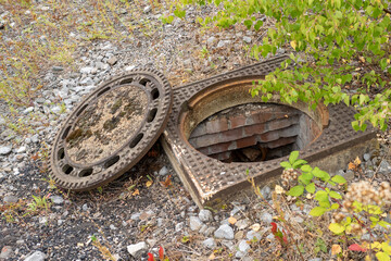 old rusty manhole cover in the landscape