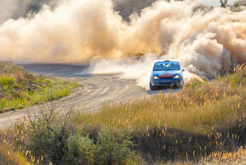 Fototapeta na wymiar Sports Car on the Turn of the Rally Track and a Lot of Dust 11