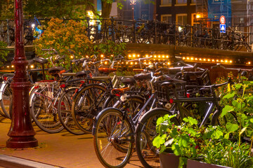 Fototapeta na wymiar Bicycles on the Night Bridge and Embankment of Amsterdam