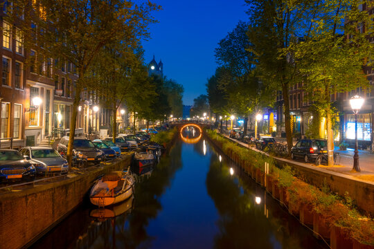 Amsterdam Night Canal With Parked Boats and Cars © goodman_ekim