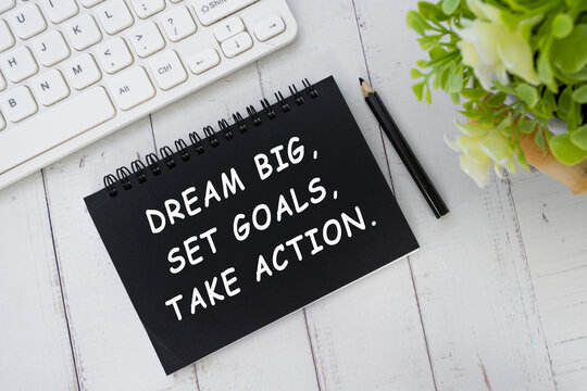 Motivational quote on black notepad - Dream big, Set goals, Take action.