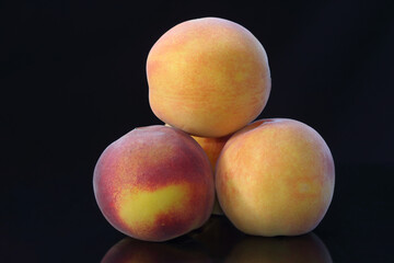 isolated peaches with reflection on dark background 