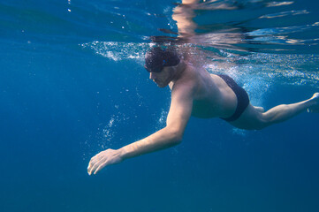 Sporty man swims fast in the sea