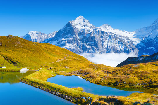 Grindelwald, Switzerland. High mountains and reflection on the surface of the lake. Mountain valley with lake. Landscape in the highlands in the summertime.