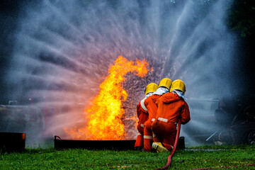 Firefighter Concept. Fireman using water and extinguisher to fighting with fire flame. firefighters...