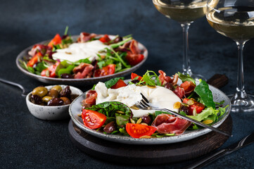 Burrata, Italian fresh cheese made from cream and milk of buffalo or cow. Burrata salad with tomatoes and salad mix. Healthy eating concept. Keto diet salad.