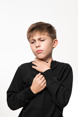 The child has a sore throat, the child is holding his throat with his hands, symptoms of throat...