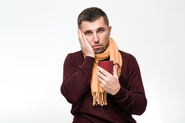 A handsome man touches his mouth with his hand with a pained expression because of toothache or tooth disease, dentist concept. - obrazy, fototapety, plakaty