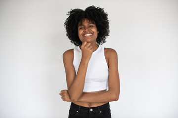 Fototapeta na wymiar Portrait of cheerful African American woman smiling at camera. Young girl wearing white crop top and jeans standing and laughing against white background. Happiness concept