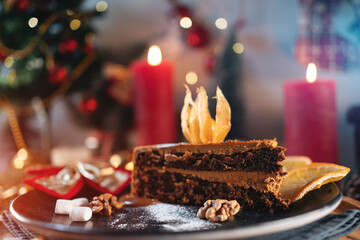 chocolate pie or cake with nut or hazelnut and brown cream at christmas decor