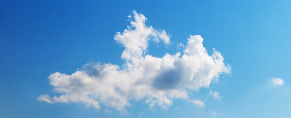 Naklejka na ściany i meble Big fluffy white cloud in blue sky in sunny weather