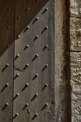 Vertical closeup shot of old gates to a castle in Aigues-Mortes, Gard, France © Pjphoto/Wirestock Creators