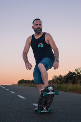 man on surfskate, surfing the  highway, in a small town , nature