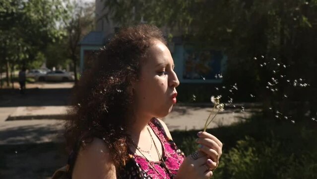 Woman Plays With Dandelon. Lovely and Funny moment and flying seeds. Summer Joy