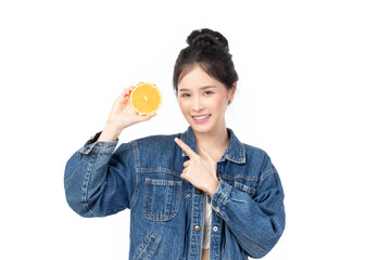 Portrait of happy asian model wearing jeans and holding juicy orange near face and smile isolated on white background.