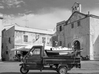 Sardaigne - Un tripoteur porte une maquette de bateau