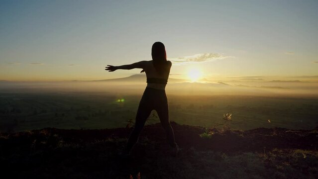 young woman dancing on the mountain at dawn