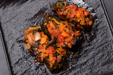 Dolma, stuffed grape leaves with rice and meat on a dark background