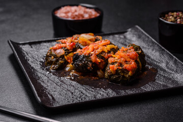 Dolma, stuffed grape leaves with rice and meat on a dark background