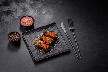 Dolma, stuffed grape leaves with rice and meat on a dark background