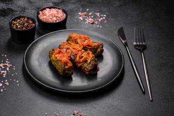 Dolma, stuffed grape leaves with rice and meat on a dark background