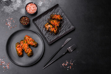 Dolma, stuffed grape leaves with rice and meat on a dark background